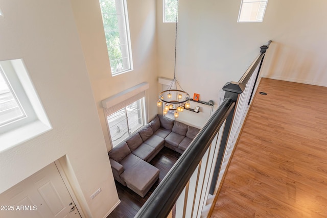706 E Washington St Unit 124, Phoenix, AZ 85034 - stairway featuring plenty of natural light, wood finished floors, a chandelier, and a towering ceiling