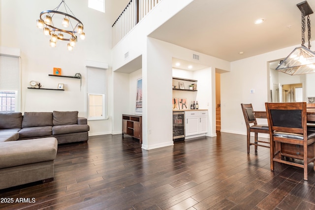 706 E Washington St Unit 124, Phoenix, AZ 85034 - living area with wine cooler, dark wood finished floors, a chandelier, a bar, and a towering ceiling