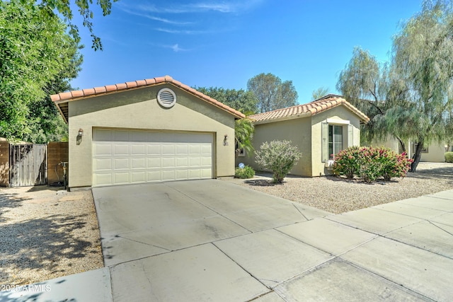 7815 S 22nd Ln, Phoenix, AZ 85041 - view of front of home with a tile roof, stucco siding, driveway, an attached garage, and a gate