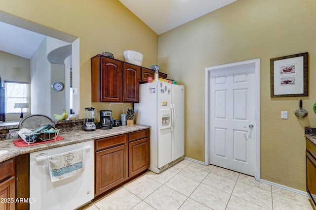7815 S 22nd Ln, Phoenix, AZ 85041 - kitchen with white appliances, lofted ceiling, light tile patterned floors, and baseboards