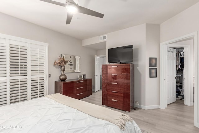 bedroom featuring a ceiling fan, light wood-style flooring, visible vents, and baseboards