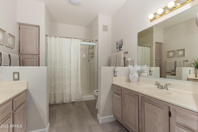 bathroom with visible vents, toilet, vanity, wood finished floors, and a shower with curtain