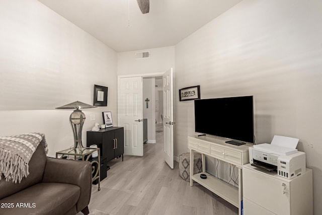 living area featuring a ceiling fan, visible vents, and light wood finished floors