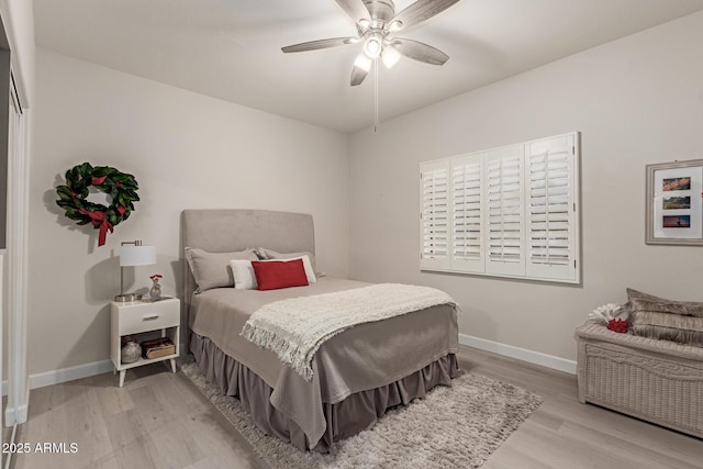 bedroom featuring ceiling fan, baseboards, and wood finished floors