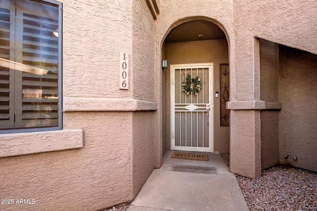 doorway to property featuring stucco siding