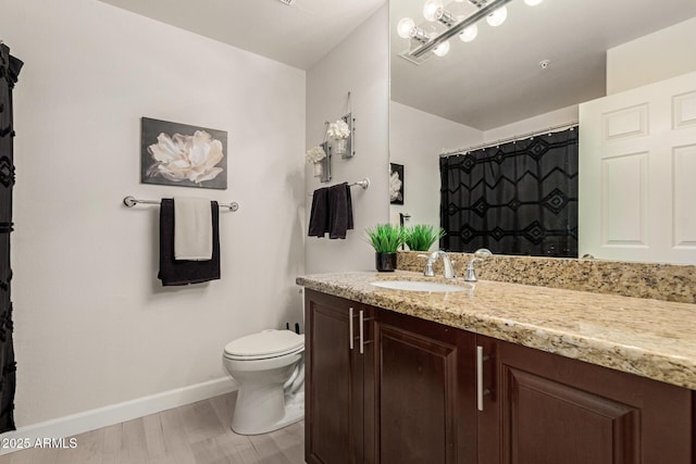 bathroom featuring curtained shower, toilet, wood finished floors, vanity, and baseboards