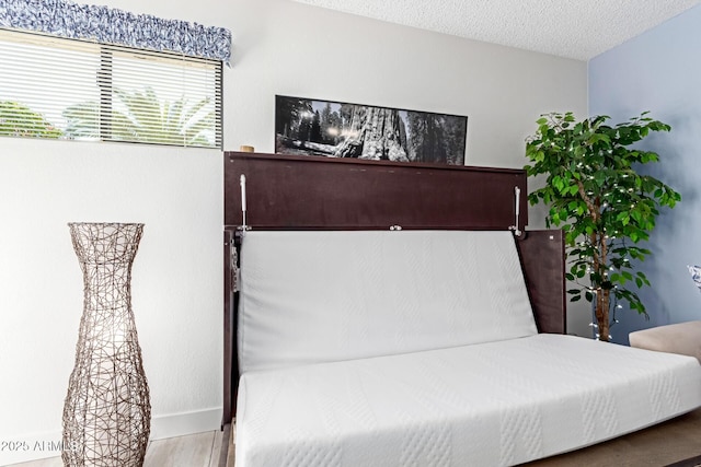 bedroom with hardwood / wood-style floors and a textured ceiling