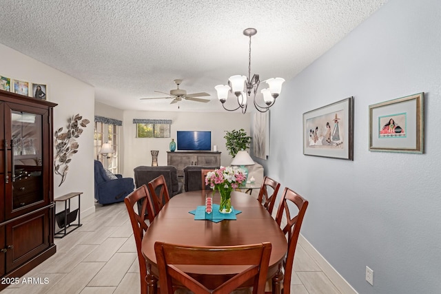 dining room featuring ceiling fan with notable chandelier and a textured ceiling