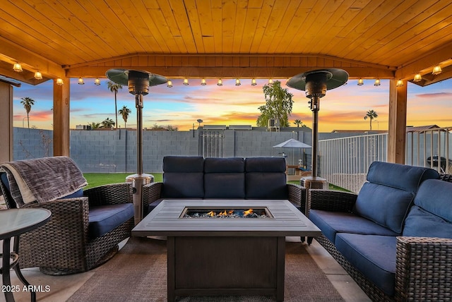 patio terrace at dusk with an outdoor living space with a fire pit