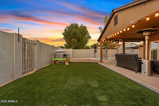 yard at dusk featuring a patio