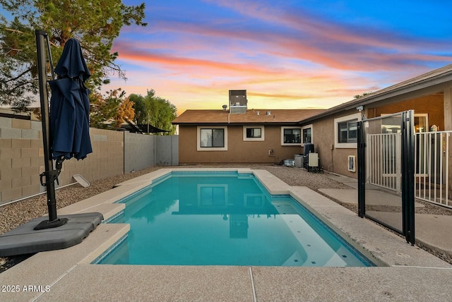 pool at dusk with a patio area