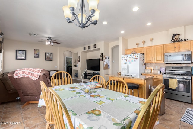 dining area featuring ceiling fan with notable chandelier and light tile patterned floors