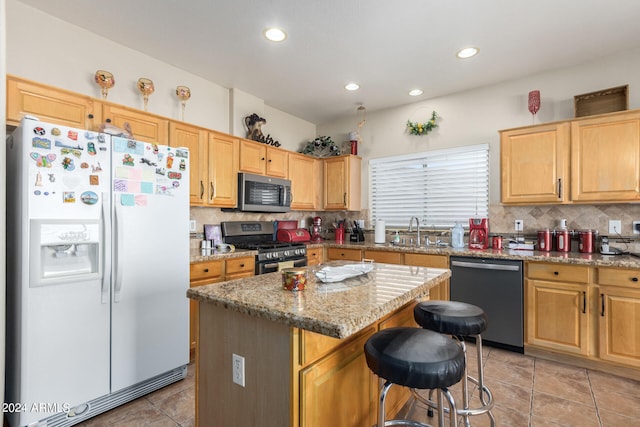 kitchen featuring appliances with stainless steel finishes, a kitchen island, decorative backsplash, and sink