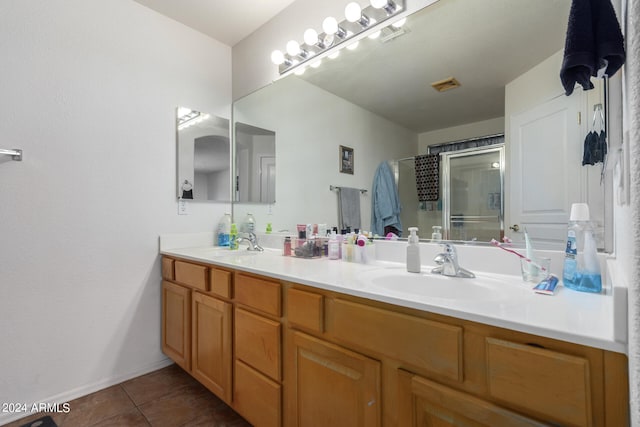 bathroom featuring walk in shower, vanity, and tile patterned flooring