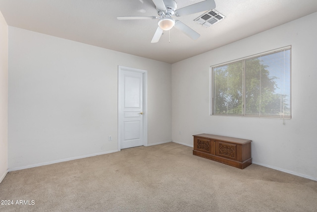 carpeted spare room featuring ceiling fan