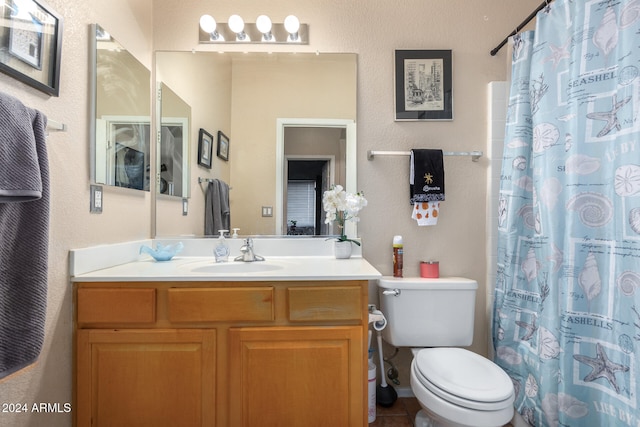 bathroom with tile patterned flooring, walk in shower, vanity, and toilet