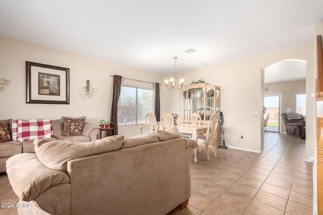 living room featuring a notable chandelier, light tile patterned floors, and a wealth of natural light