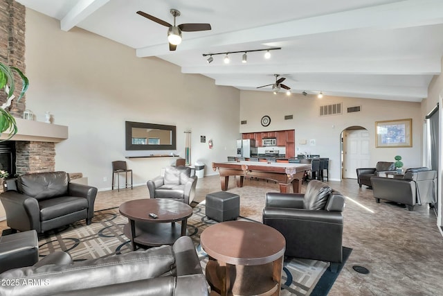 living room featuring ceiling fan, a fireplace, lofted ceiling with beams, and billiards