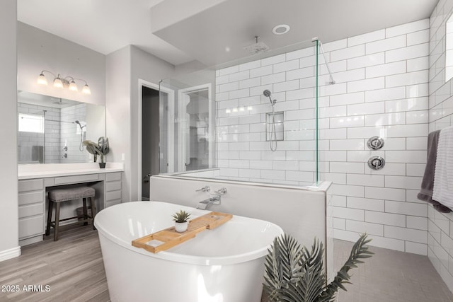 bathroom with hardwood / wood-style flooring, vanity, and shower with separate bathtub