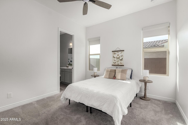 bedroom featuring multiple windows, light colored carpet, connected bathroom, and ceiling fan