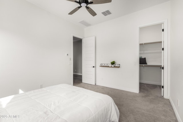 carpeted bedroom featuring a closet, ceiling fan, and a spacious closet