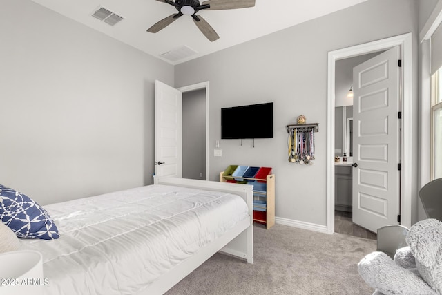 bedroom featuring light colored carpet, ensuite bath, and ceiling fan