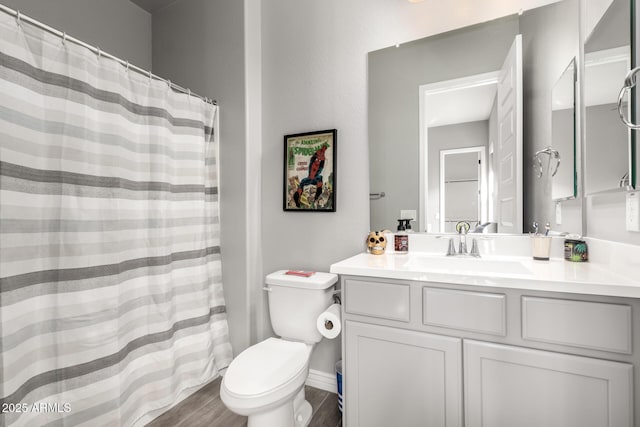 bathroom with hardwood / wood-style flooring, toilet, and vanity