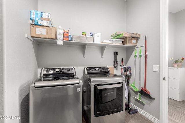 washroom with light wood-type flooring and washing machine and clothes dryer