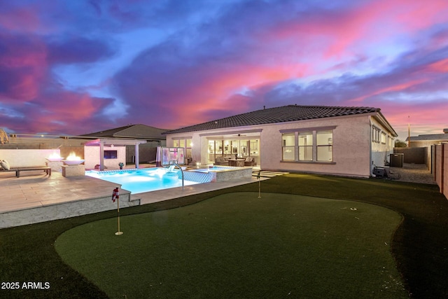 pool at dusk featuring a patio