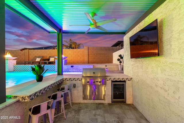 view of patio featuring an outdoor bar, an outdoor kitchen, ceiling fan, and a grill