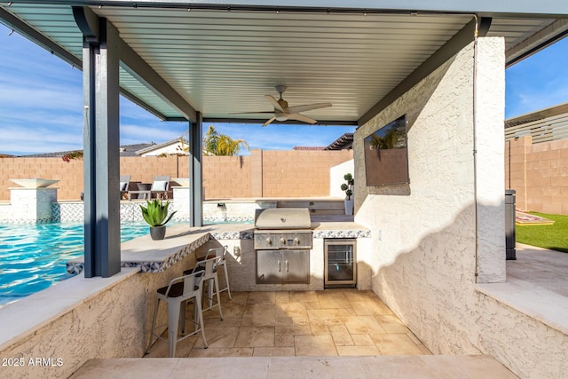 view of patio featuring wine cooler, ceiling fan, an outdoor bar, area for grilling, and a grill