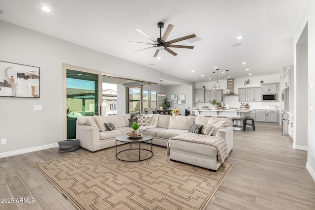 living room with light hardwood / wood-style floors and ceiling fan