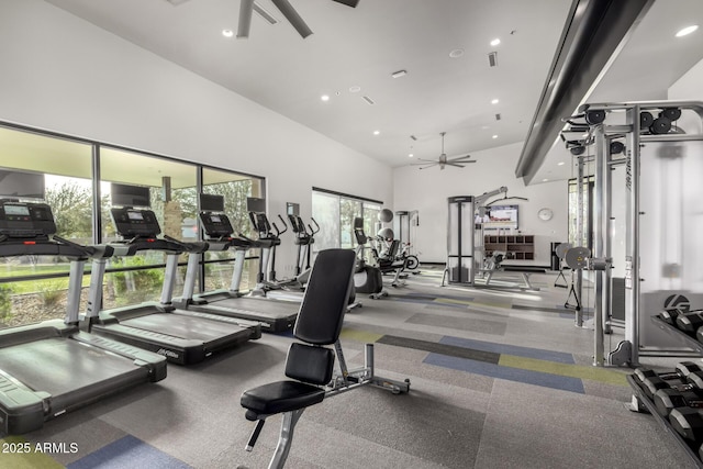 workout area with ceiling fan and a towering ceiling