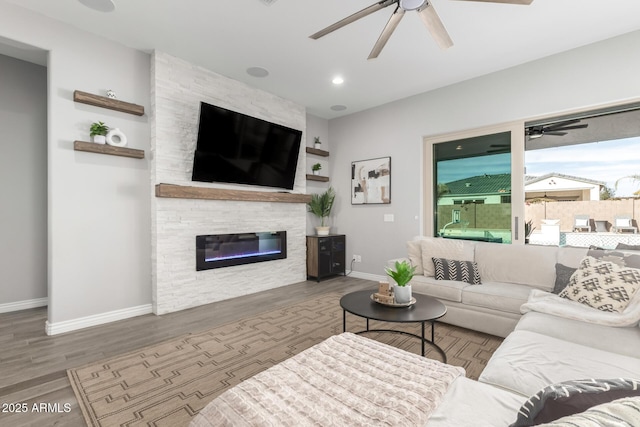 living room featuring a fireplace, ceiling fan, and dark hardwood / wood-style flooring