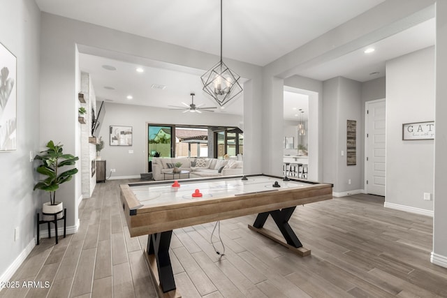 recreation room featuring ceiling fan with notable chandelier, hardwood / wood-style floors, and billiards