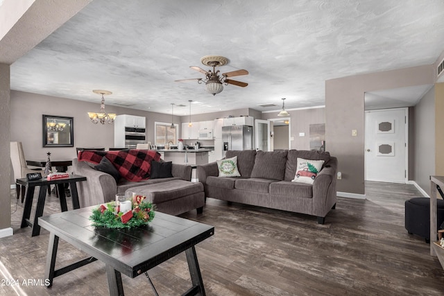 living room with wood-type flooring, ceiling fan with notable chandelier, a textured ceiling, and sink