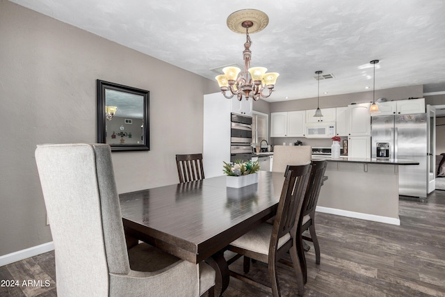 dining area with dark hardwood / wood-style floors, sink, and a chandelier