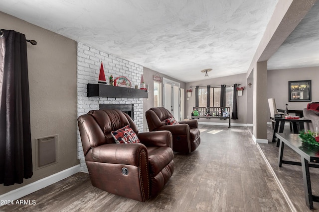 living room featuring lofted ceiling, wood-type flooring, and a brick fireplace