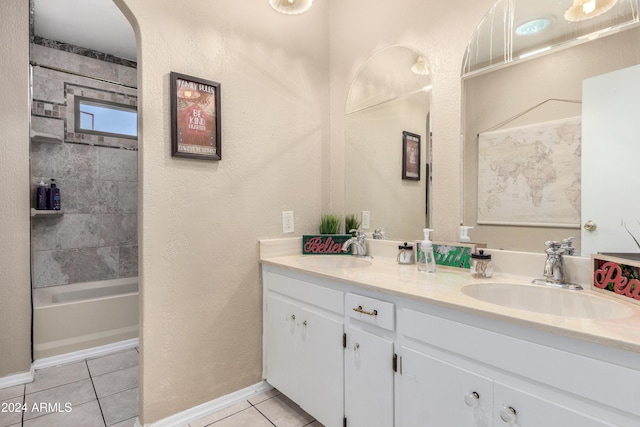 bathroom featuring tile patterned flooring, vanity, and tiled shower / bath