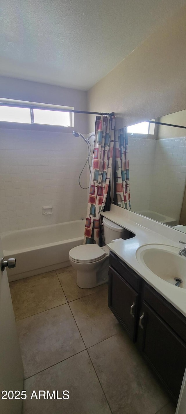 bathroom with a textured ceiling, shower / bath combination with curtain, tile patterned flooring, vanity, and toilet