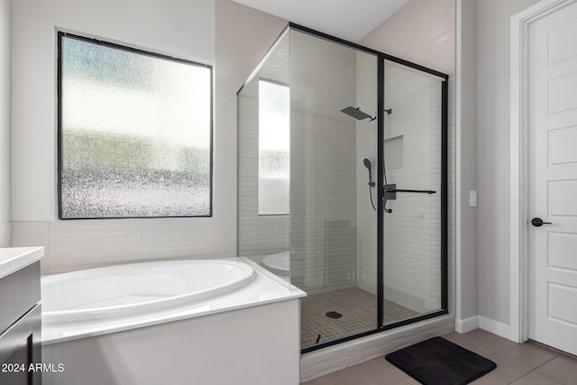 bathroom featuring shower with separate bathtub, vanity, and tile patterned floors