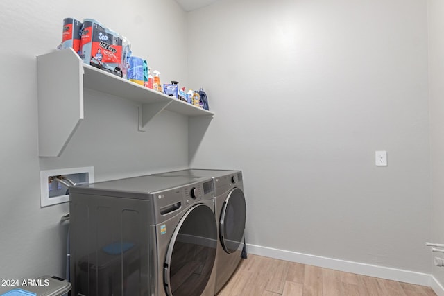 clothes washing area featuring washing machine and dryer and light hardwood / wood-style flooring