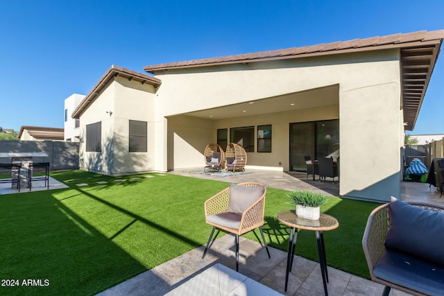 rear view of property featuring a yard and a patio area