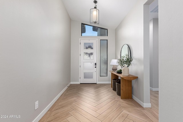 foyer with light parquet flooring and lofted ceiling