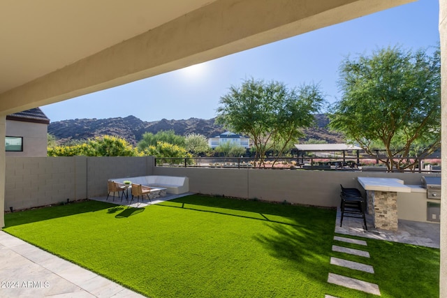 view of yard featuring a mountain view, an outdoor bar, a patio, and an outdoor kitchen