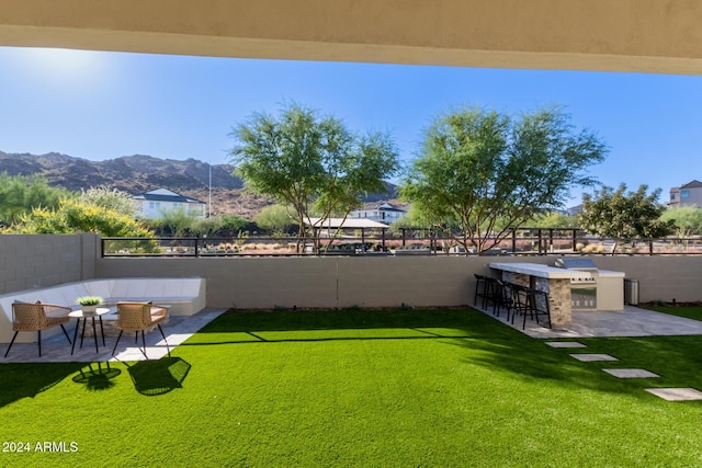 view of yard with area for grilling, a mountain view, a patio area, and a bar