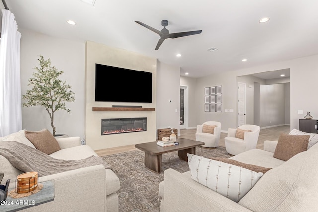 living room with ceiling fan and a fireplace