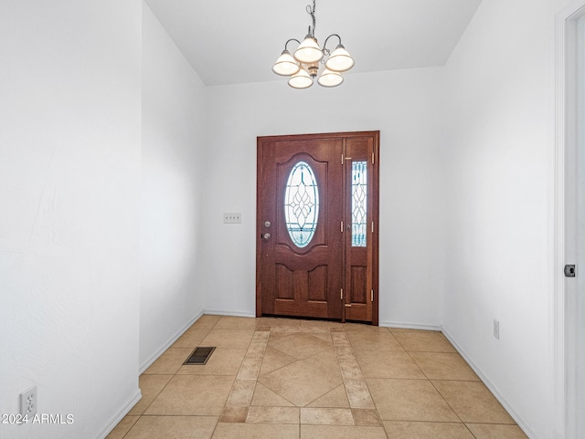 entrance foyer with a notable chandelier, visible vents, baseboards, and light tile patterned floors