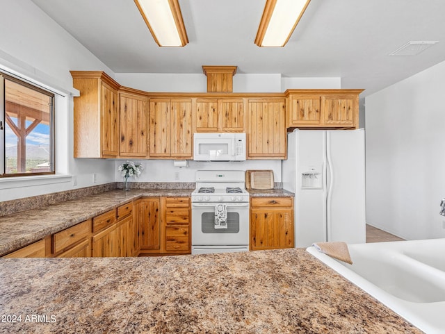 kitchen with white appliances, light stone countertops, and visible vents