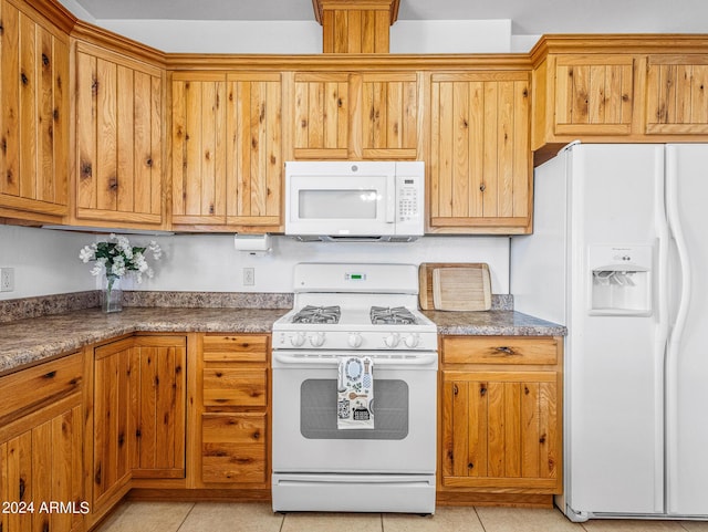 kitchen featuring light tile patterned flooring, brown cabinets, and white appliances